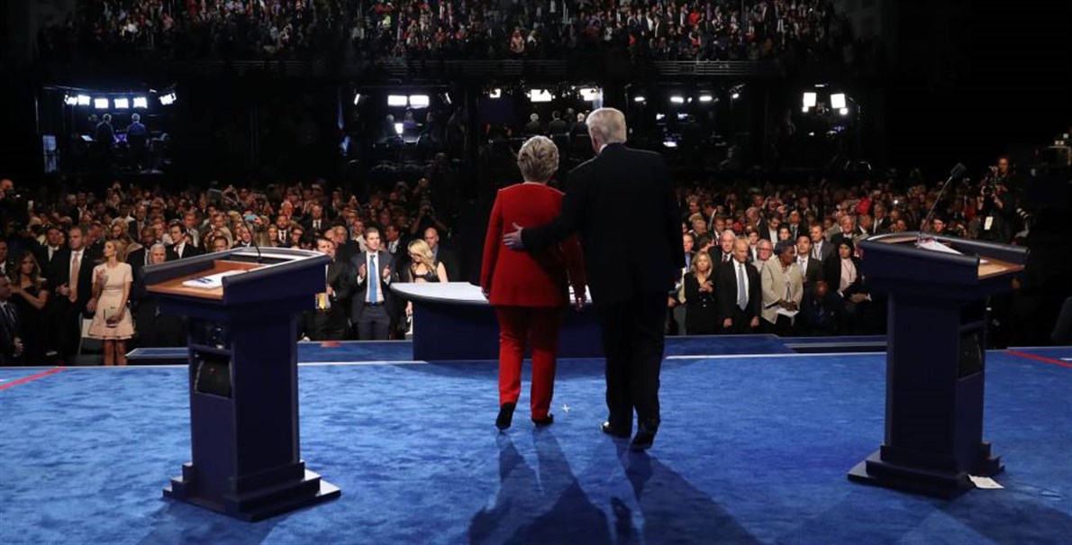 Los candidatos a la presidencia de los Estados Unidos, Hillary Clinton y Donald Trump saludan al público tras finalizar el debate.