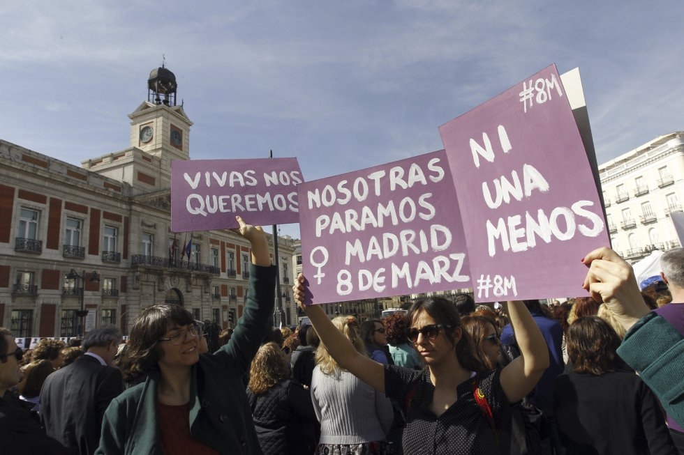 Tres personas alzan carteles con motivo del Día Internacional de la Mujer en la Puerta del Sol, en Madrid (España).