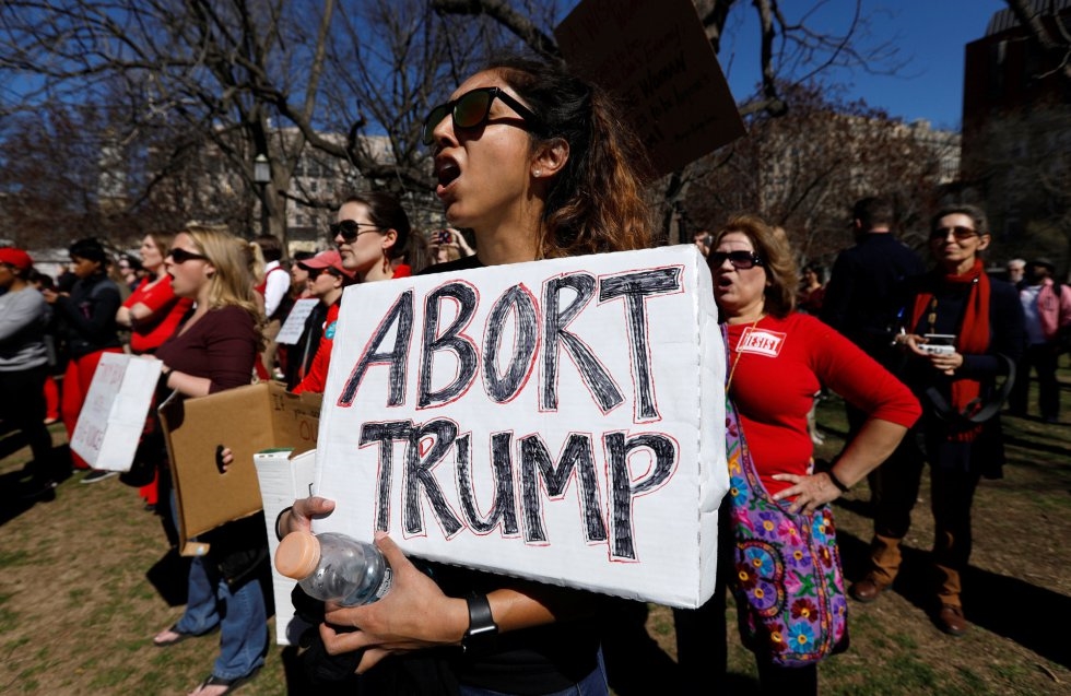 Una manifestante sostiene un letrero durante la manifestación en el exterior de la Casa Blanca como parte de la huelga Un día sin mujer en el Día Internacional de la Mujer en Washington (EE UU).