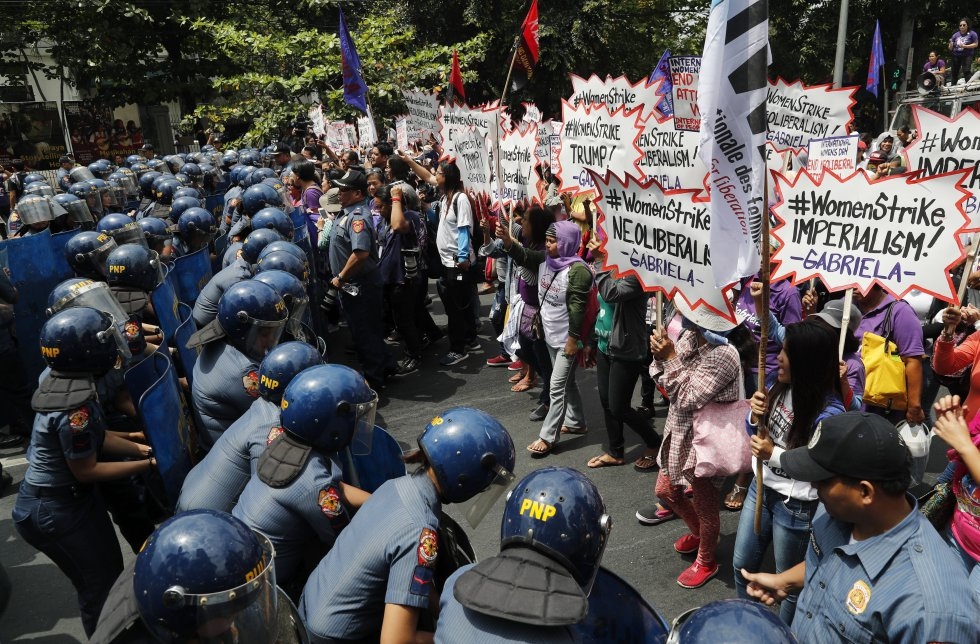 La policía bloquea el paso de las manifestantes que participan en una marcha por el Día de la Mujer, en Manila (Filipinas).