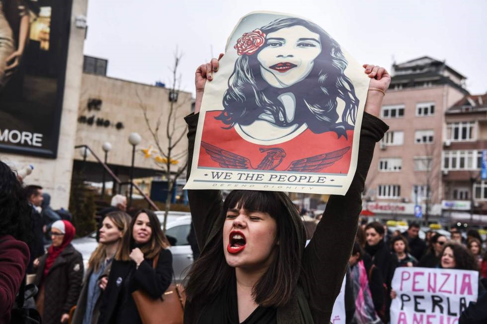 Una mujer sostiene un póster de la artista norteamericana Shepard Ferey mientras participa en una manifestación por la igualdad de género y contra la violencia hacia las mujeres celebrado en Pristina (Kosovo).