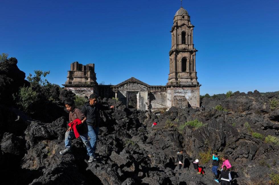 Visitantes pasean en el interior de la iglesia, actualmente el turismo es el principal ingreso en la zona. Cada año, miles de visitantes llegan al volcán para observar las ruinas que siguen intactas, tal y como la lava las sepultó, después de 75 años. MAR
