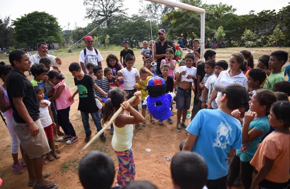 En el polideportivo Matias Romero se intenta entretener a los niños con juegos y actividades infantiles. Por ejemplo, con una piñata que un grupo de ellos se afana en romper con un palo. VICTORIA RAZO AFP