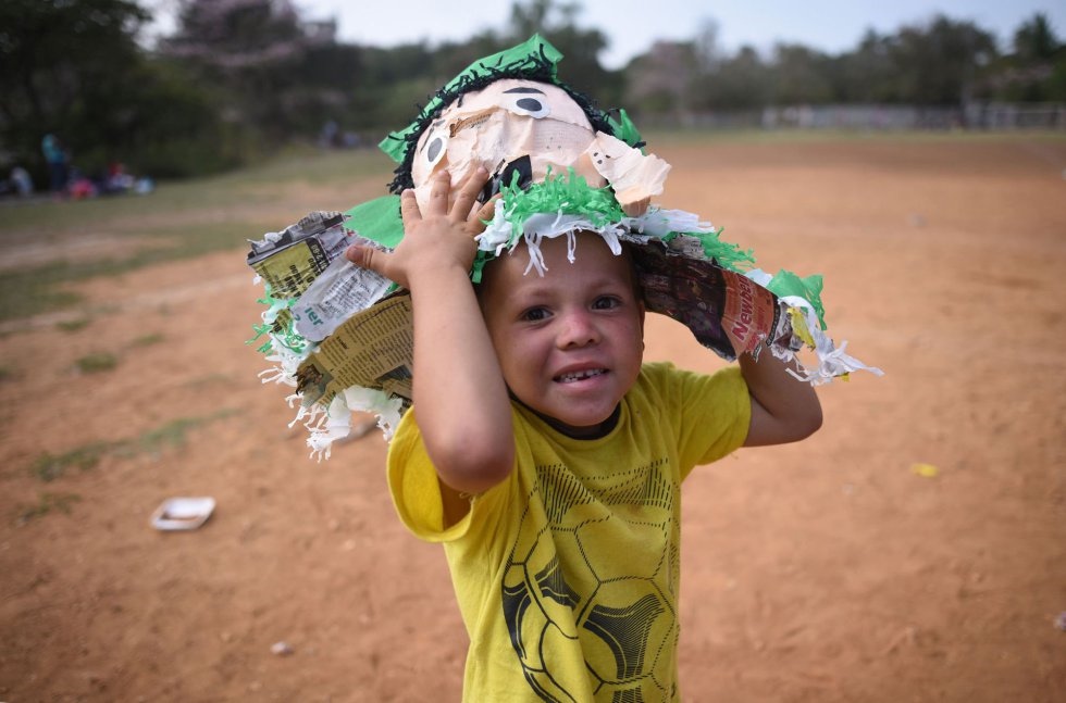 Un niño que camina con su familia en el Viacrucis migrante posa ante la cámara con los restos de la piñata. VICTORIA RAZO AFP