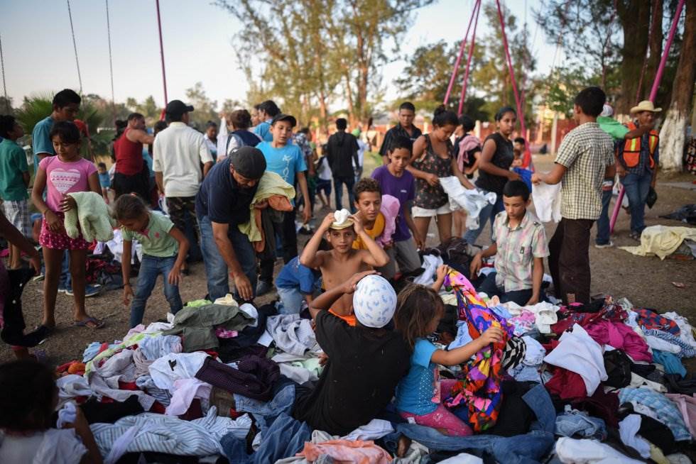 Un grupo de centroamericanos del Víacrucis migrante rebusca ropa útil de un montón enorme de prendas donadas en el polideportivo de Matías Romero, la ciudad oaxaqueña que los está acogiendo. VICTORIA RAZO AFP