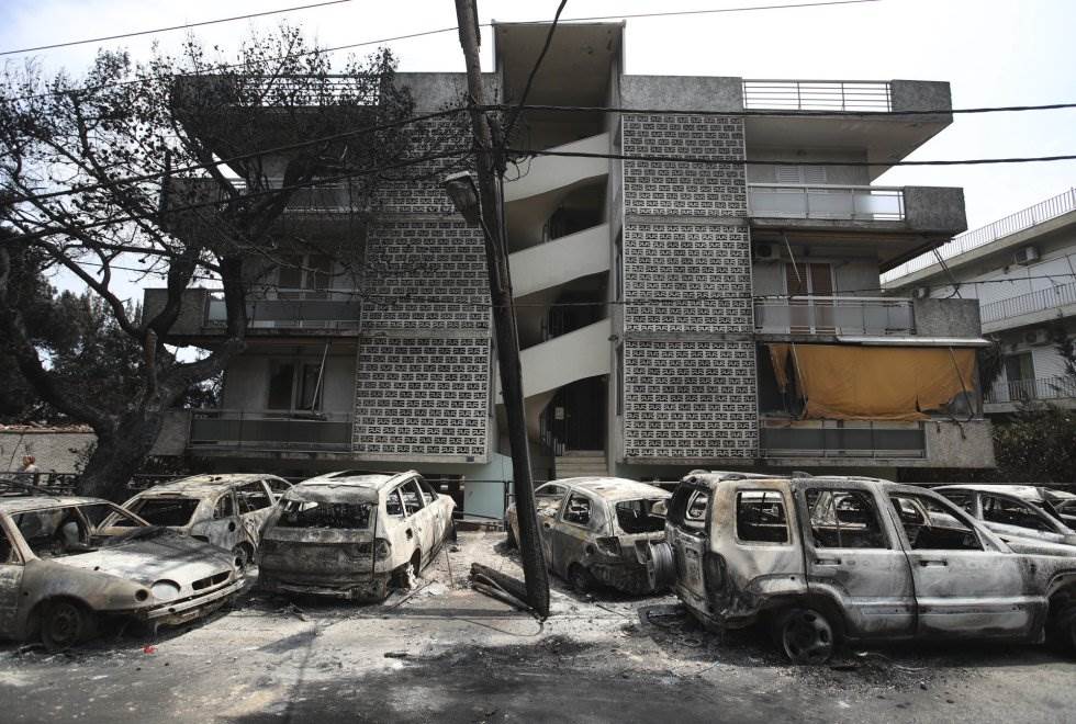 Coches incendiados frente a un bloque de apartamentos en Mati, al este de Atenas.
