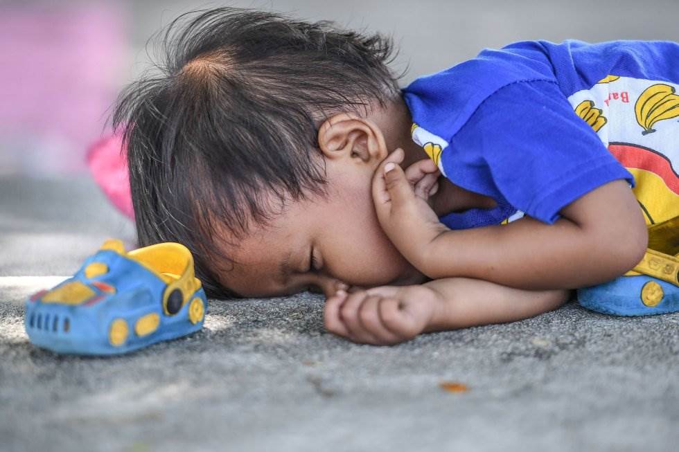 Un niño duerme a las afueras de un campamento improvisado en Palu. MOHD RASFAN AFP