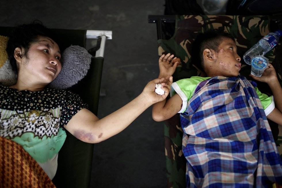 Una madre y su hijo, ambos heridos, esperan para ser evacuados en un avión militar en Indonesia. ATHIT PERAWONGMETHA REUTERS