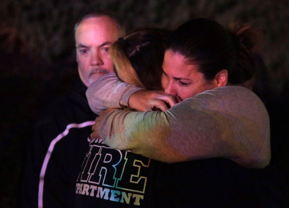 20 Una mujer que ha huido del lugar del tiroteo abraza a sus familiares, en el Borderline Bar&Grill, en la localidad de Thousand Oaks, en las afueras de Los Ángeles.