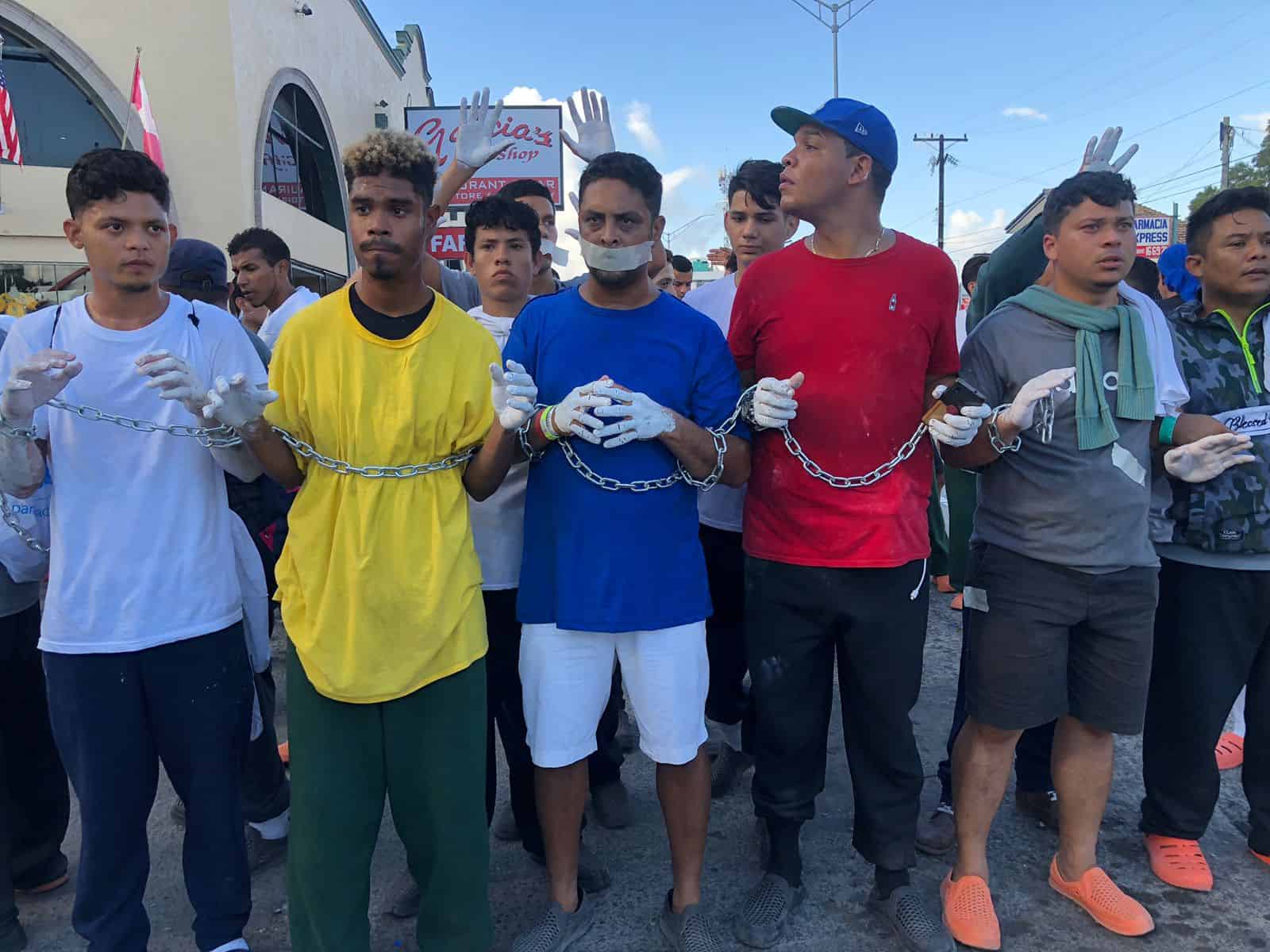 Con las manos pintadas en blanco y encadenados, la comunidad migrante de Venezuela marcharon por las calles.  (Foto: Miguel Jiménez)